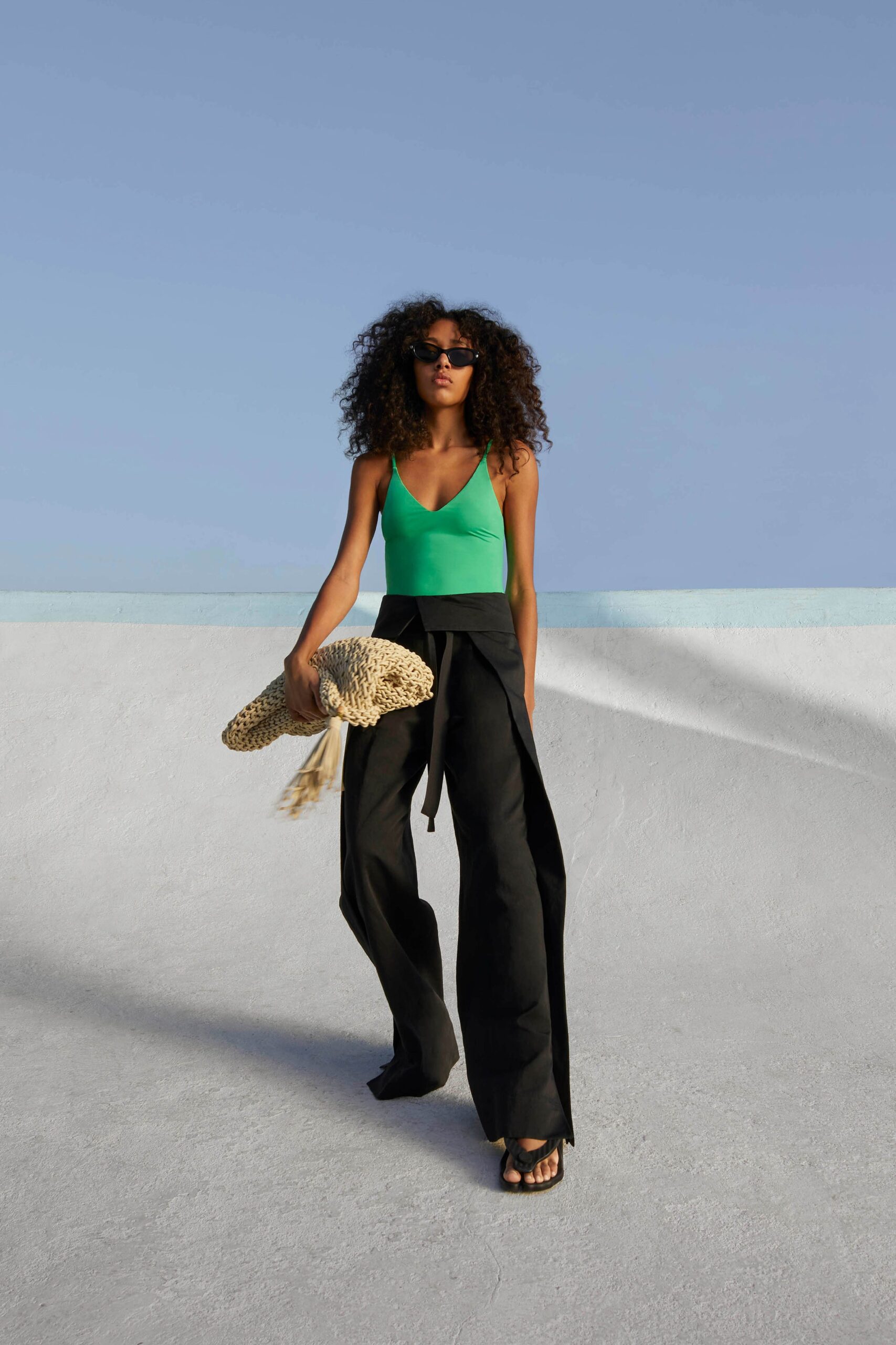 green fitted top with black pants