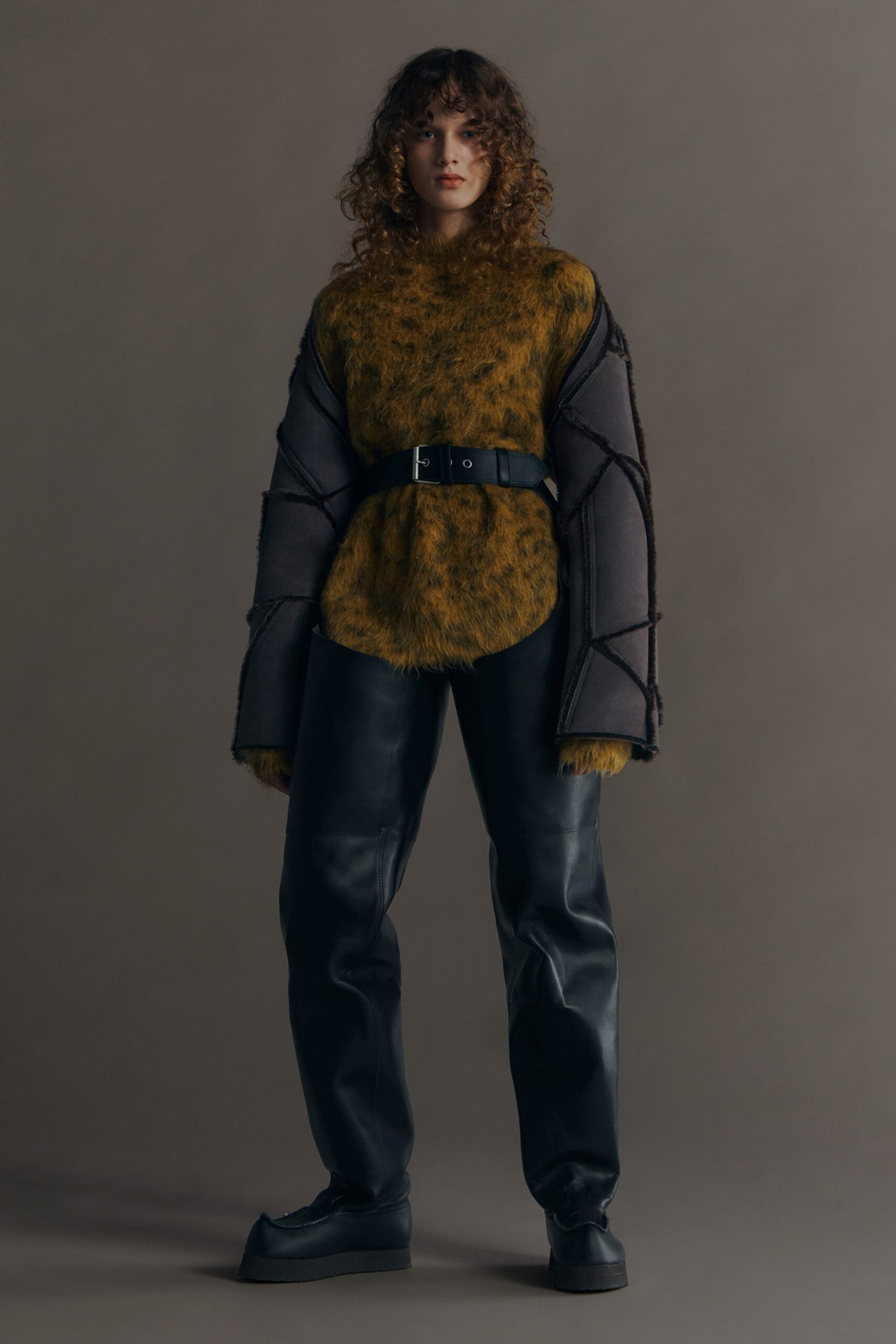 green and gray relaxed top with black leather pants