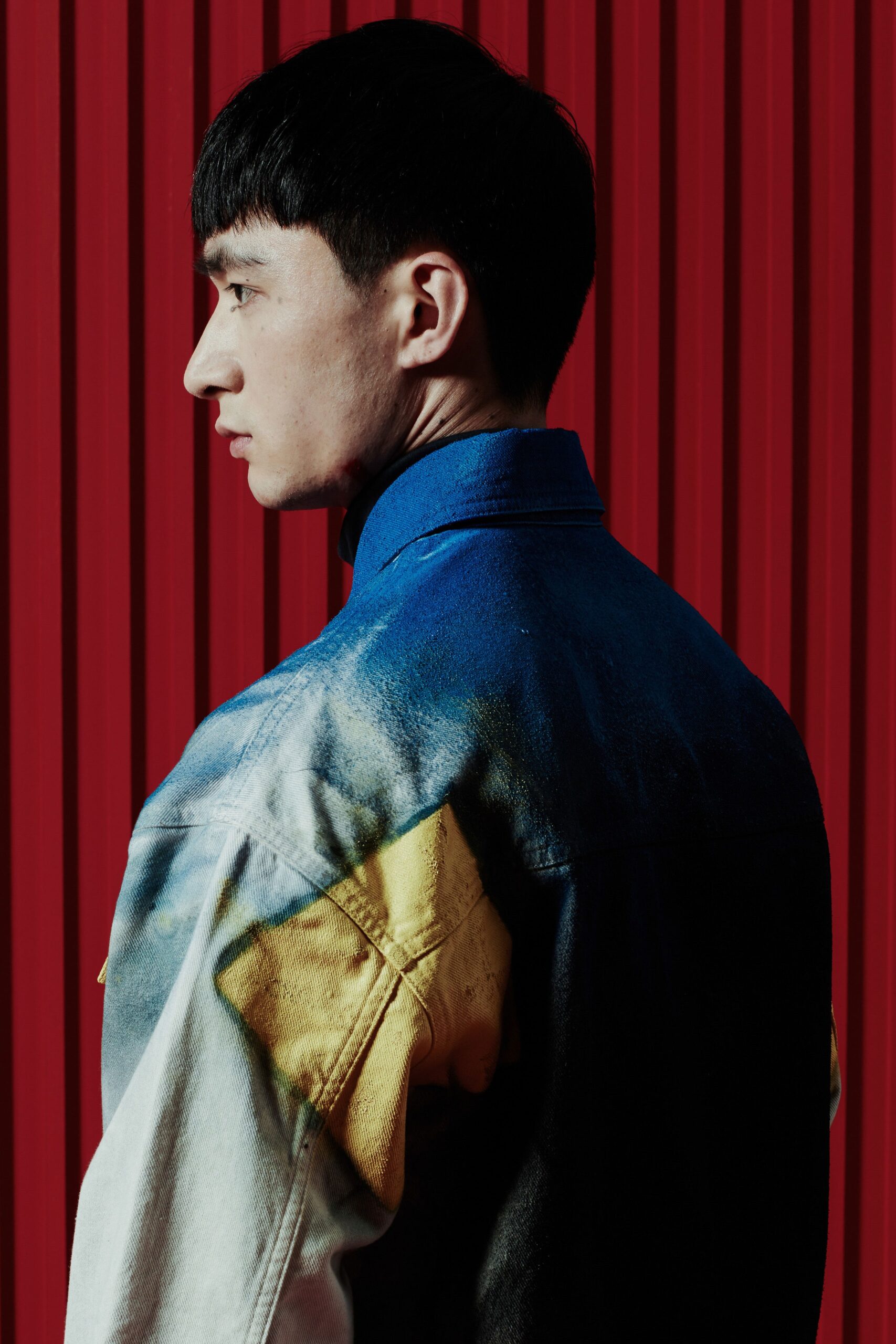 A relaxed fit color-blocked denim jacket with long sleeves and a collared neckline.