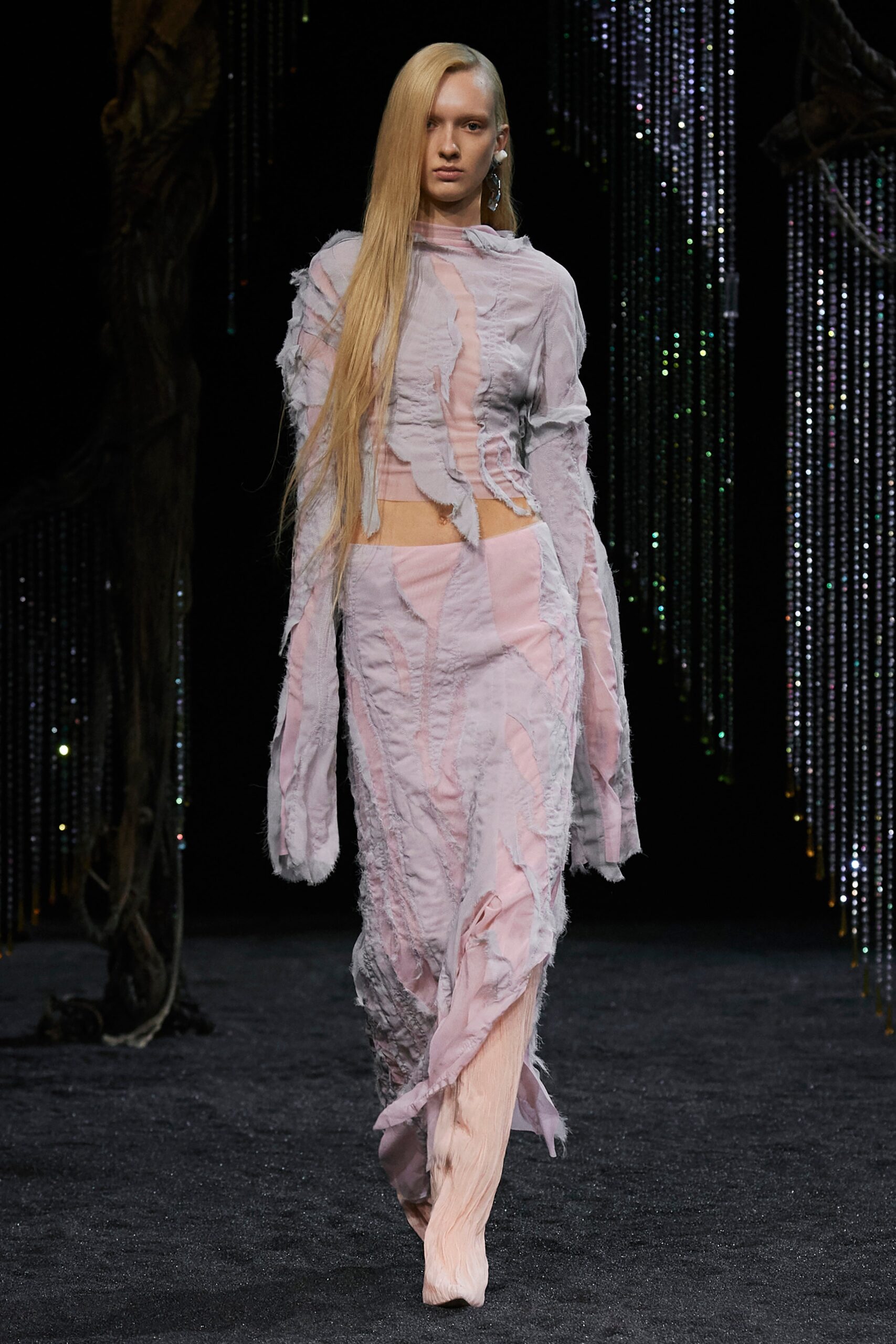 A fitted pink and purple dress with long sleeves and an asymmetric layered design.