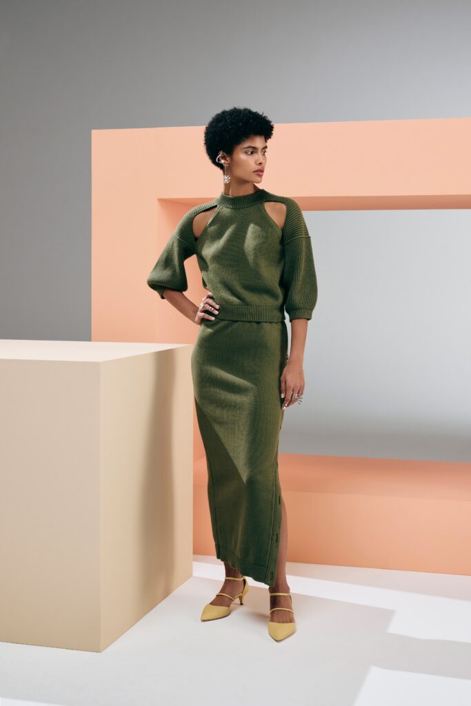A fitted green knit dress with cutout details and a side slit.