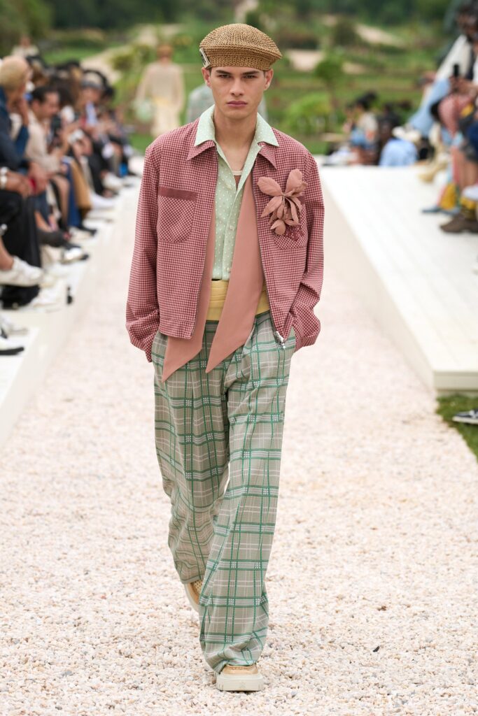 A relaxed pink checked jacket with a collared neckline paired with flared green pants.