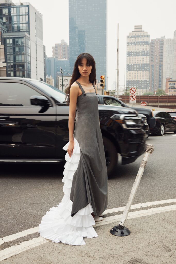 A fitted gray and white sleeveless dress with a V-neckline and tiered design.