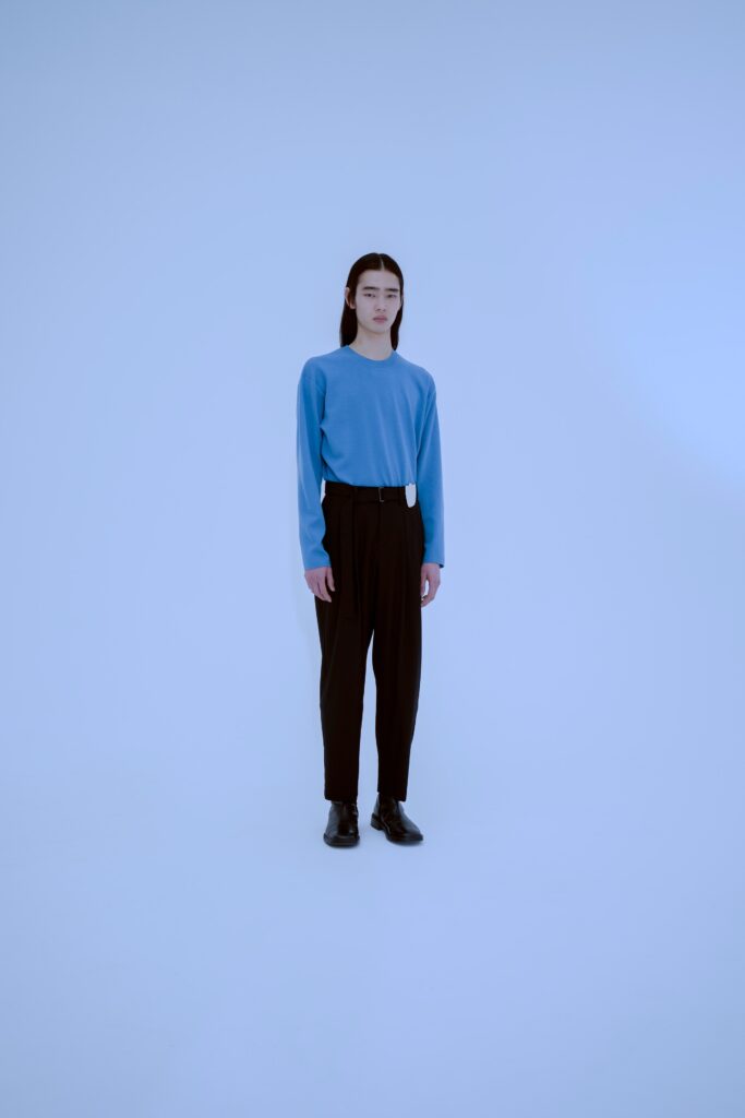 A relaxed blue cotton long-sleeve top paired with straight-leg black pants.