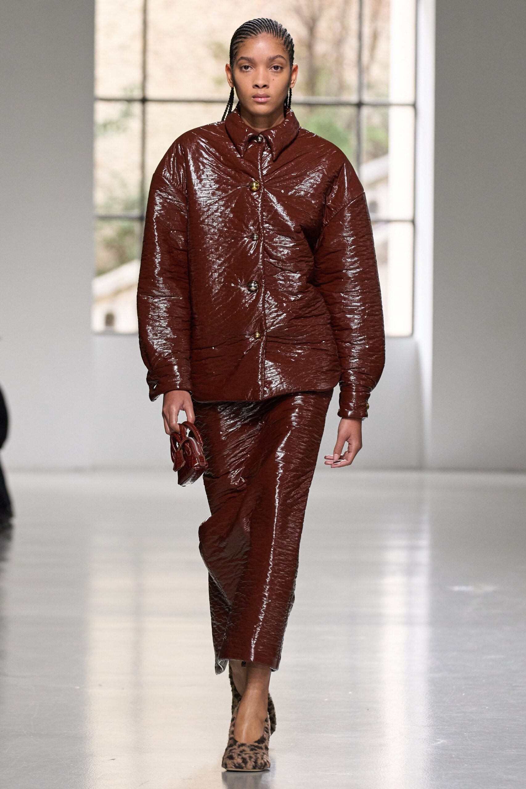 A relaxed brown silk jacket with a collared neckline paired with a pleated skirt.