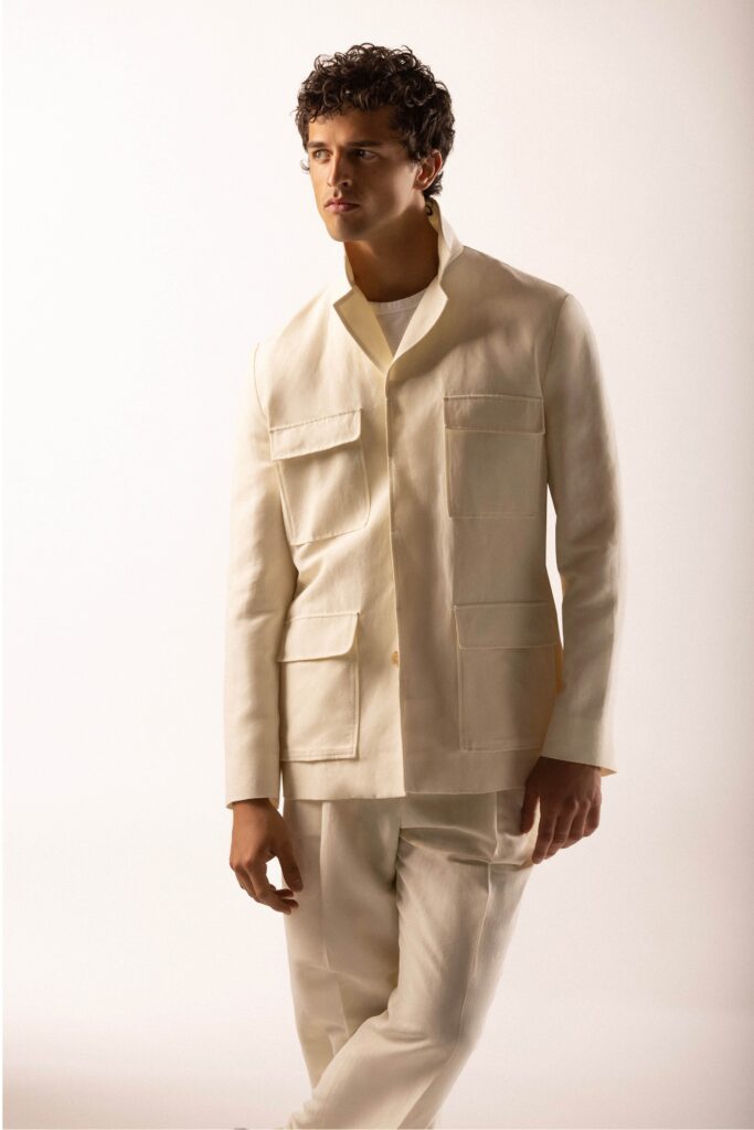A fitted beige cotton jacket with long sleeves and a collared neckline paired with matching pants.
