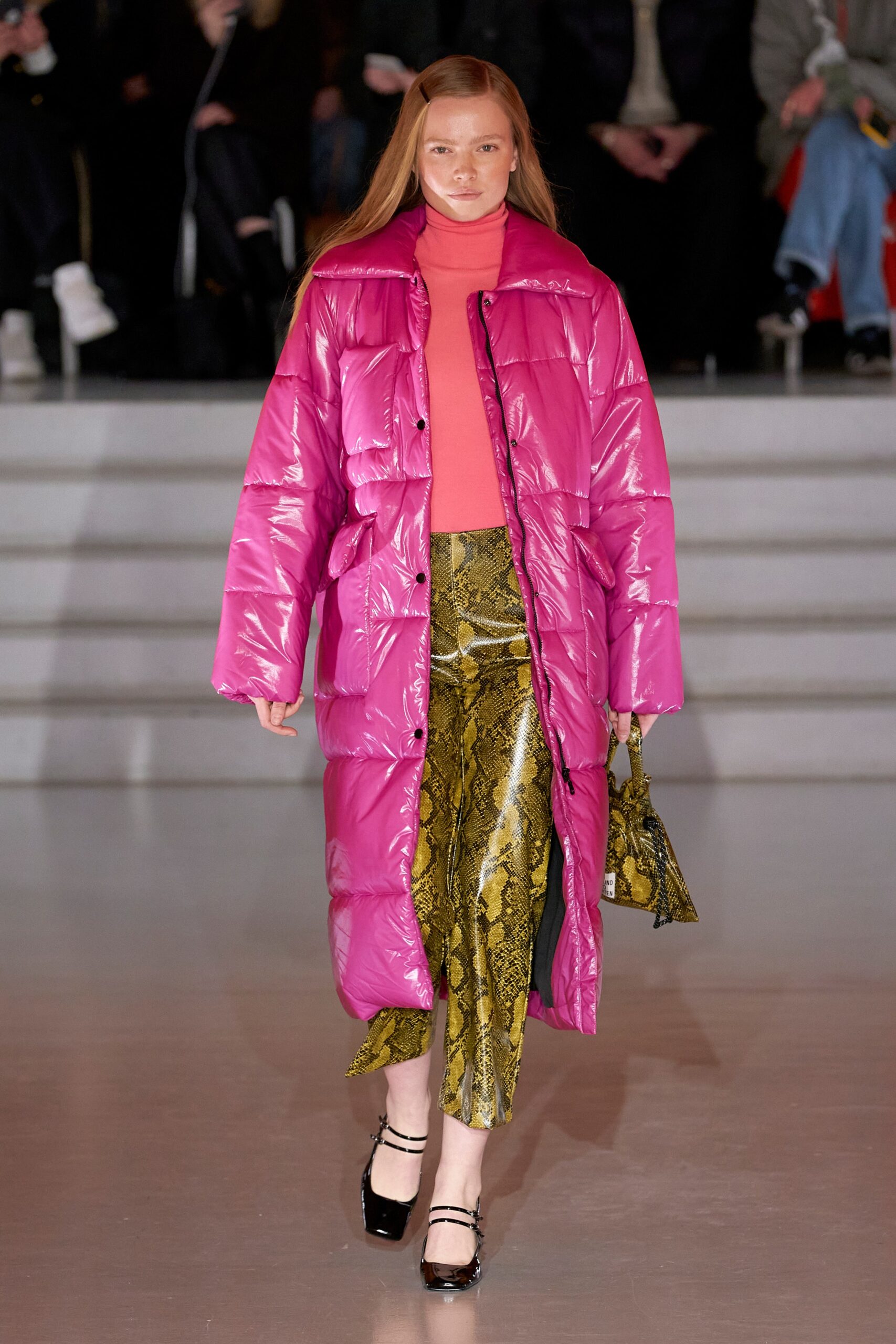 A relaxed pink coat paired with a printed skirt featuring an asymmetric design.