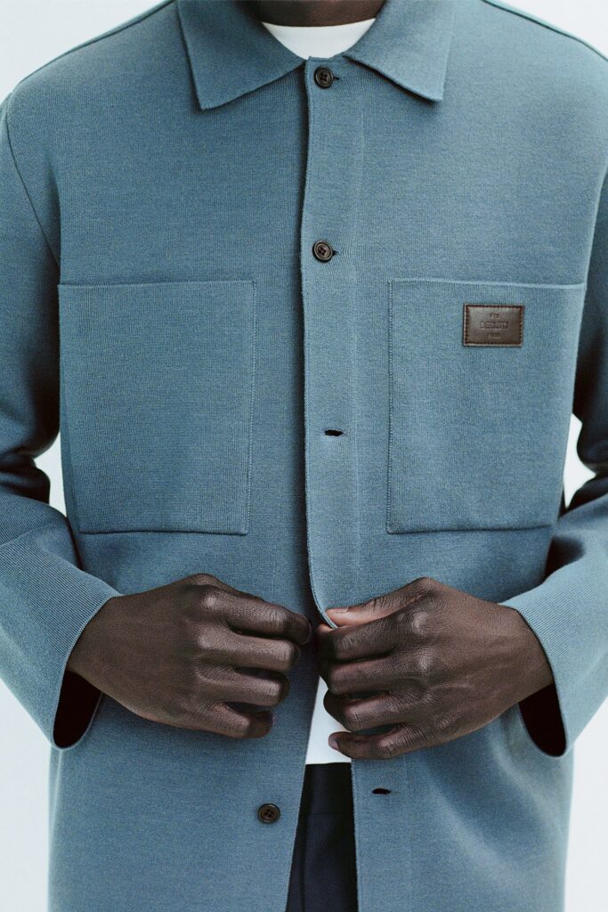 A relaxed blue cotton jacket with long sleeves and a collared design, featuring buttoned details.