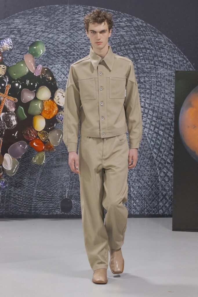 A relaxed beige cotton jacket with long sleeves and collared design paired with straight-leg pants.