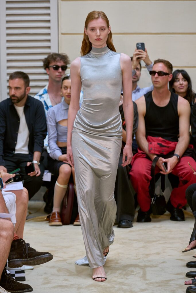 A fitted silver silk dress with a high neckline and straight silhouette.