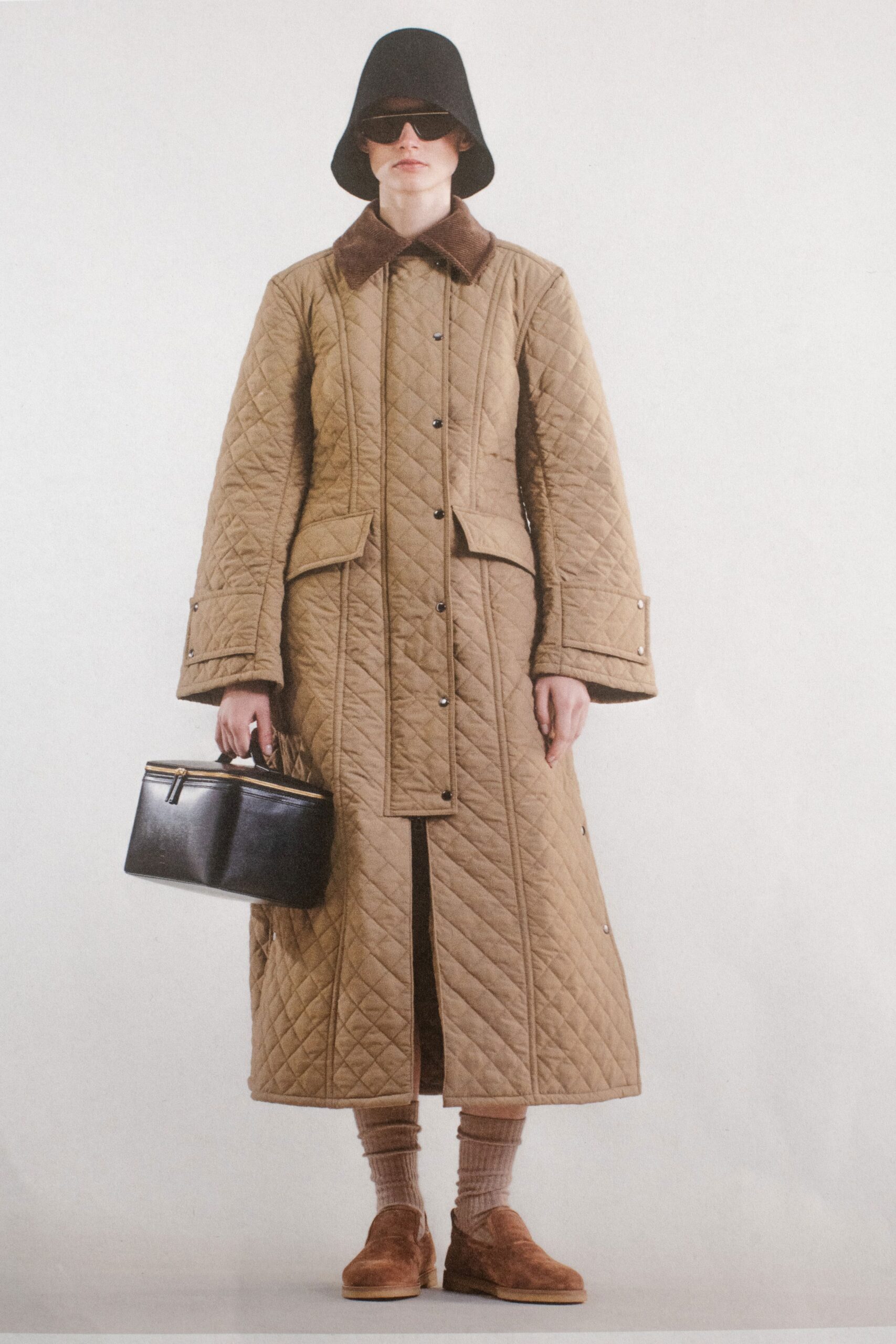 A relaxed brown quilted coat with long sleeves and a collared neckline.