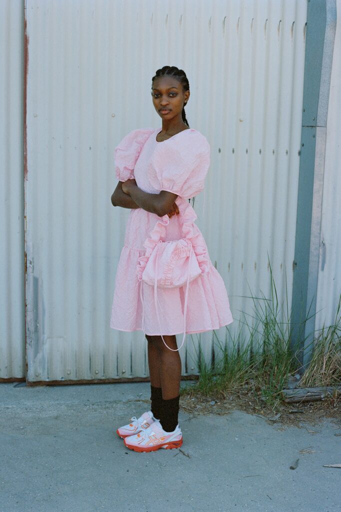 A relaxed pink cotton dress with short sleeves and a tiered design.