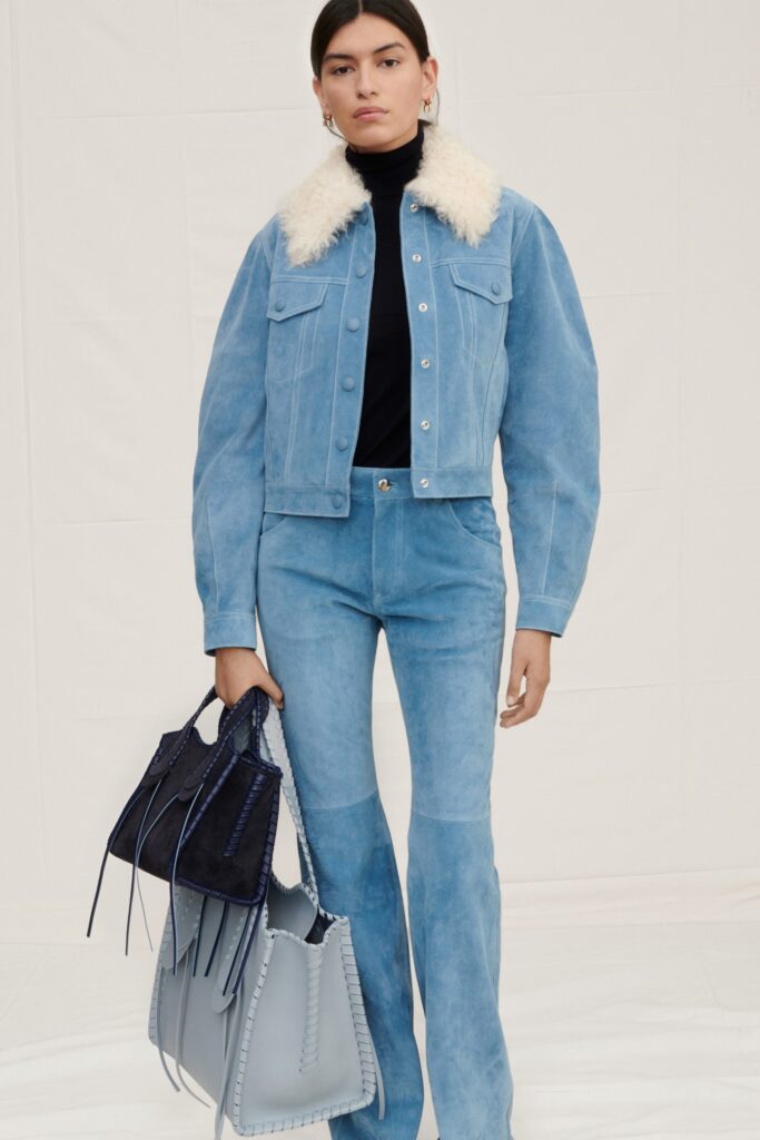A fitted blue suede jacket with a collared neckline paired with straight-leg pants.