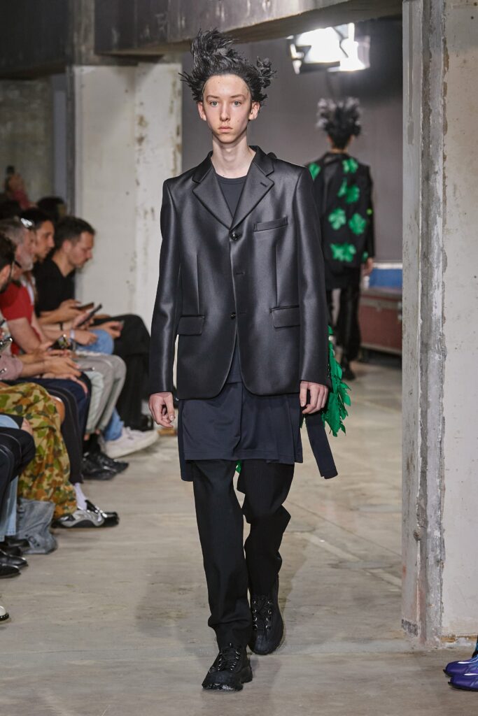 A relaxed black silk jacket with long sleeves and asymmetric design paired with matching pants.