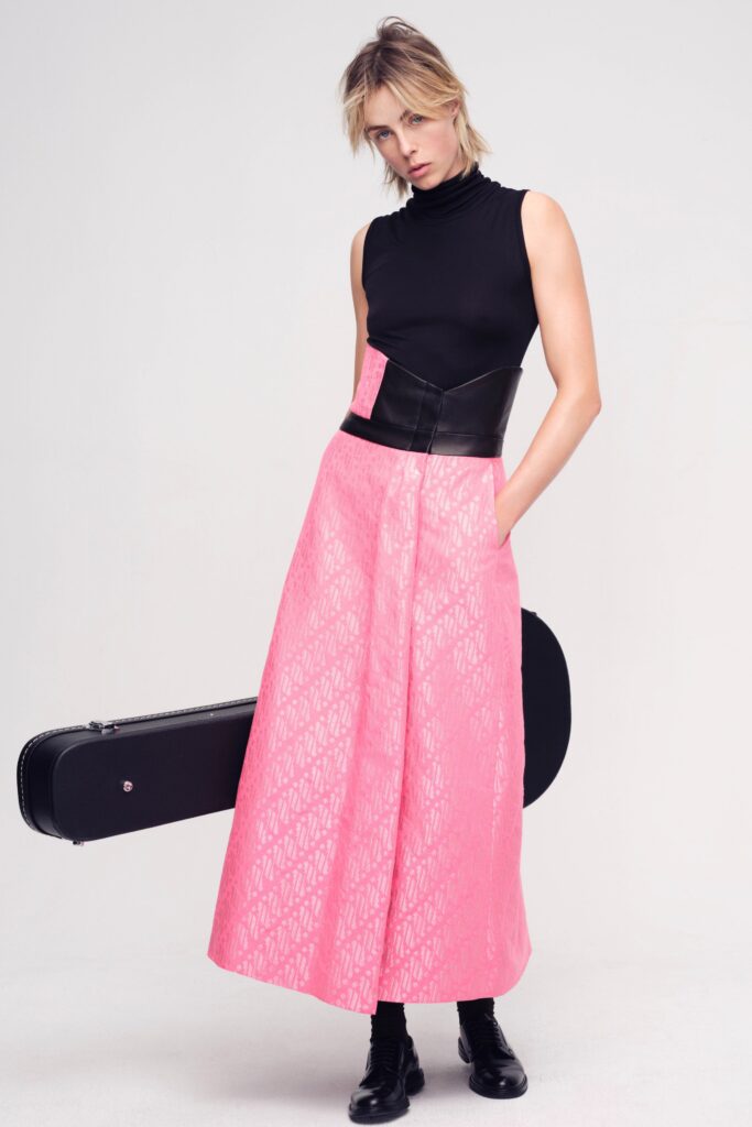 A fitted sleeveless dress featuring a black top and a tiered pink skirt with an asymmetric design.