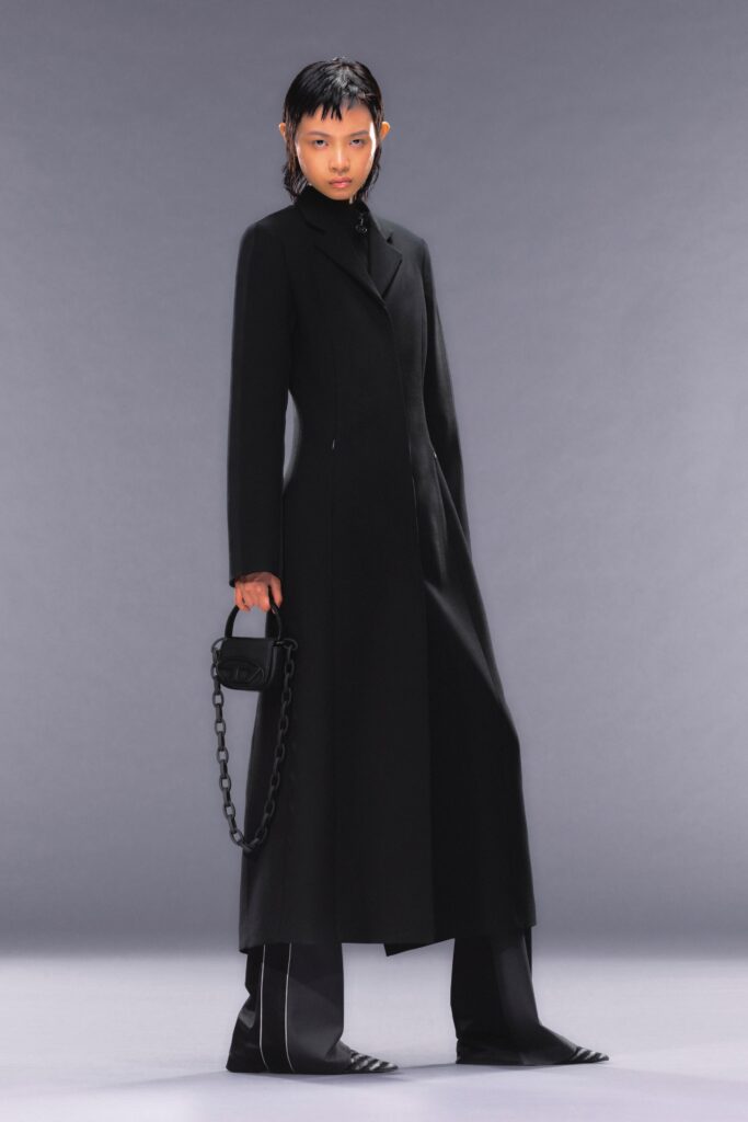 A fitted black wool coat with long sleeves and a collared neckline, featuring straight-leg pants.