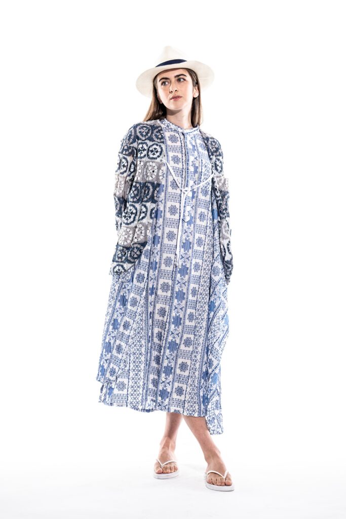 A relaxed blue cotton dress with long sleeves, a collared neckline, and a tiered design.