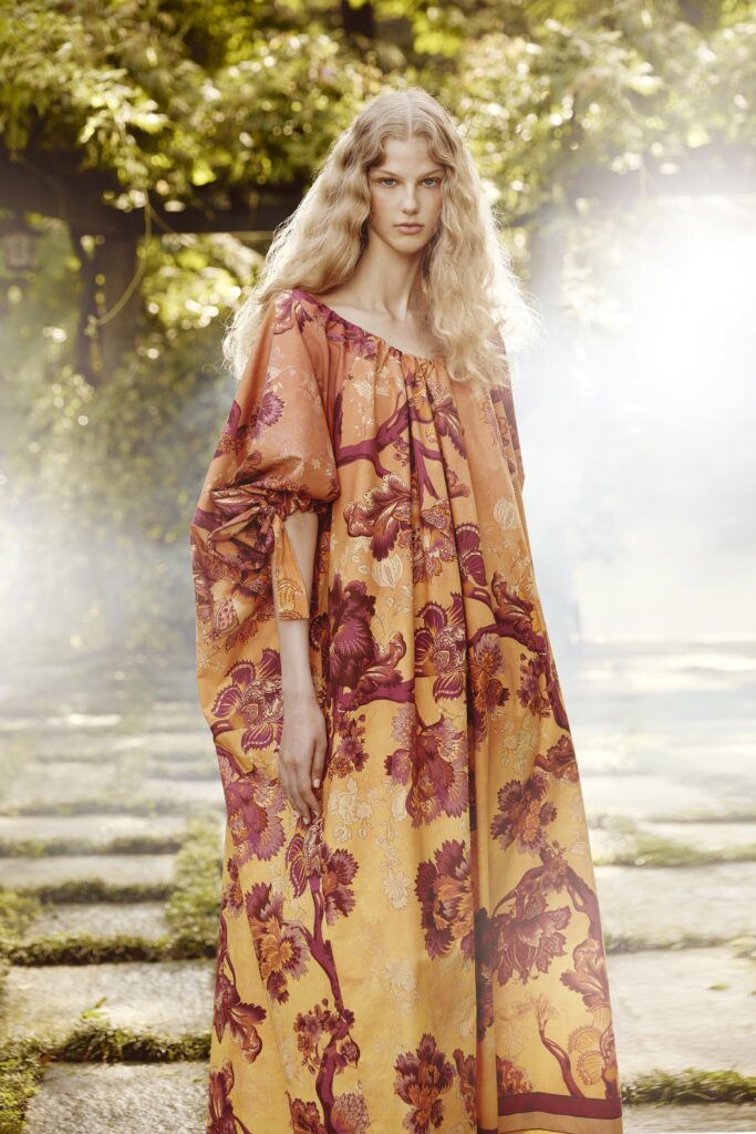 A relaxed orange and purple floral dress with long sleeves and an off-shoulder design.