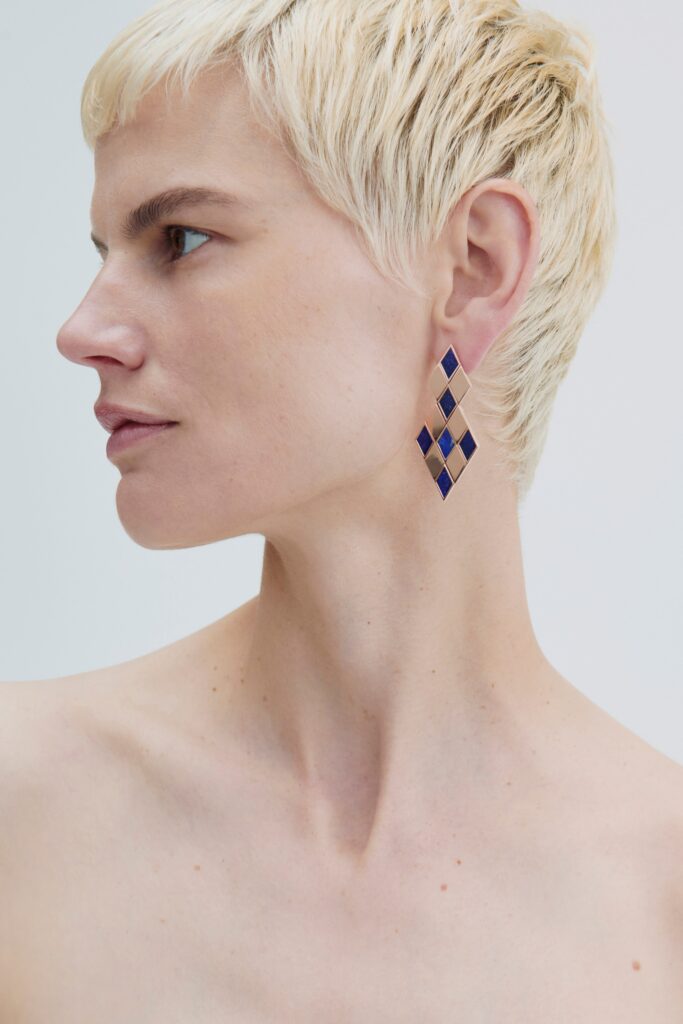 beige silk sleeveless top with earrings