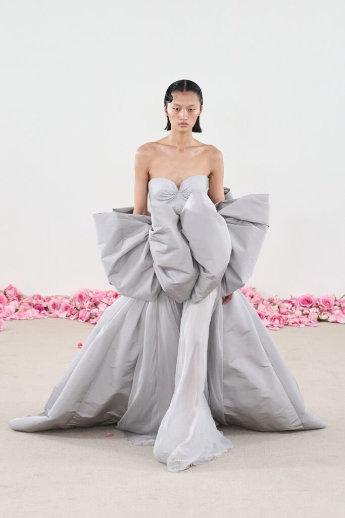 A fitted gray silk strapless gown with an asymmetric and layered design.