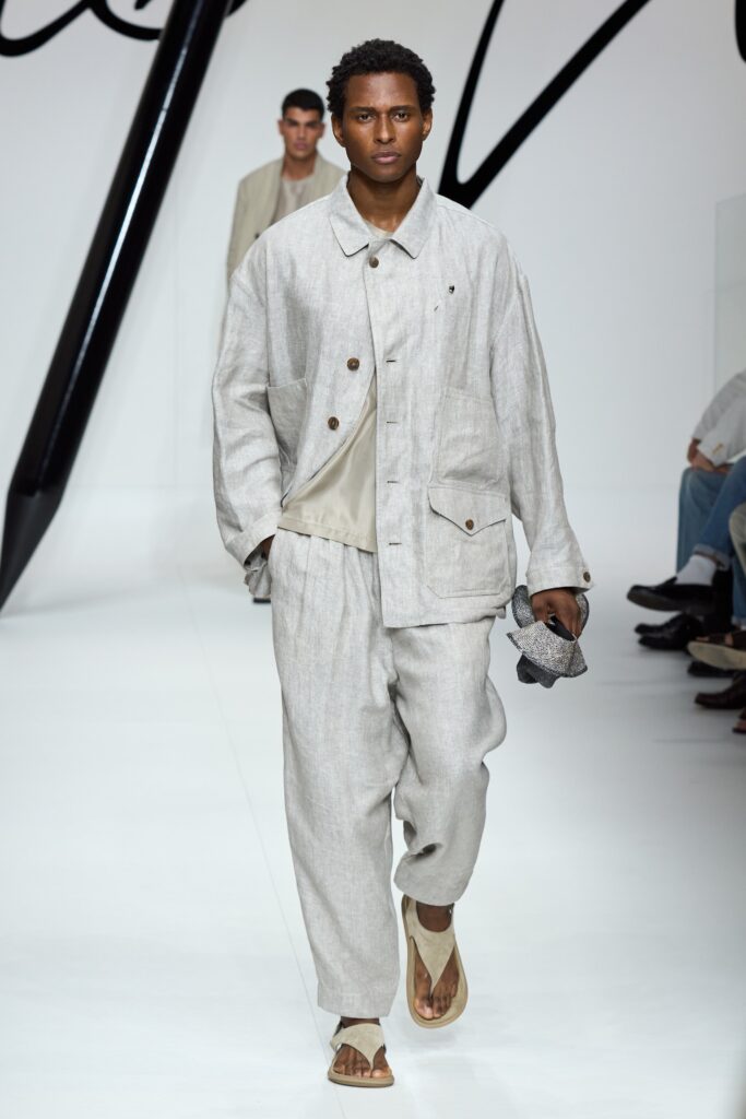 A relaxed beige linen jacket with long sleeves and collared design paired with matching pants.