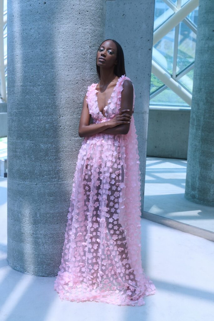 A fitted pink silk sleeveless dress with a V-neckline and layered design.