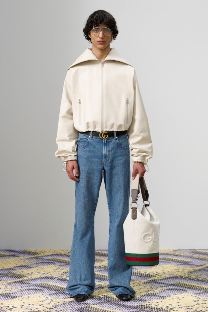 A relaxed white long-sleeve jacket with a collared design paired with flared blue denim pants.