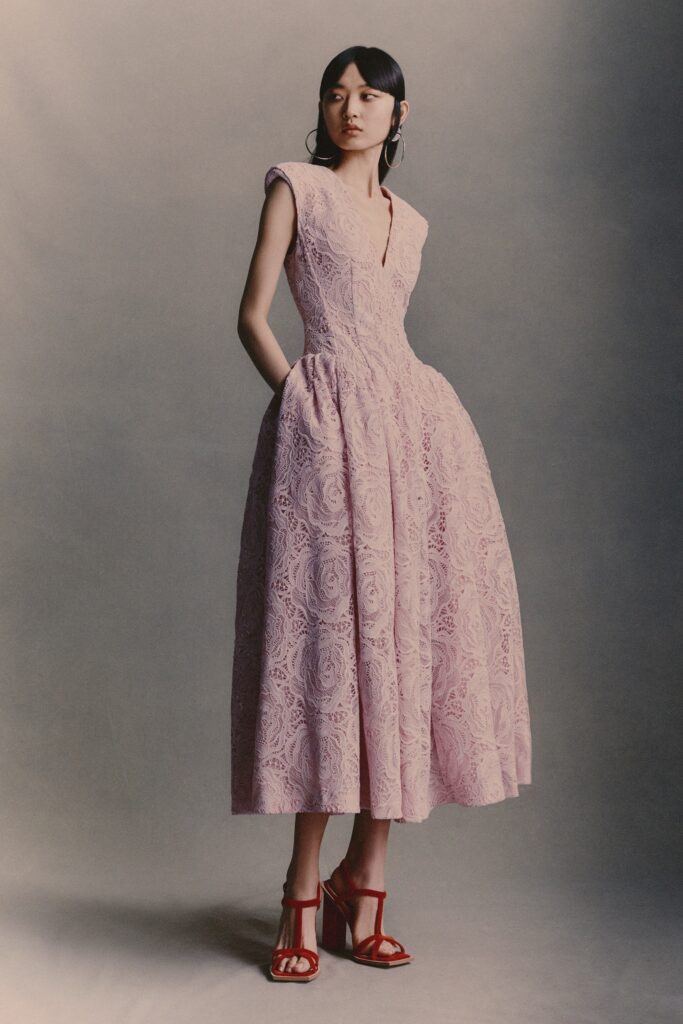 A fitted pink lace sleeveless dress with a V-neckline and A-line silhouette.