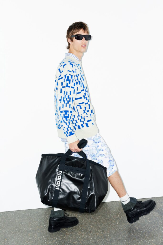 A relaxed blue printed sweater paired with white shorts, perfect for a casual look.