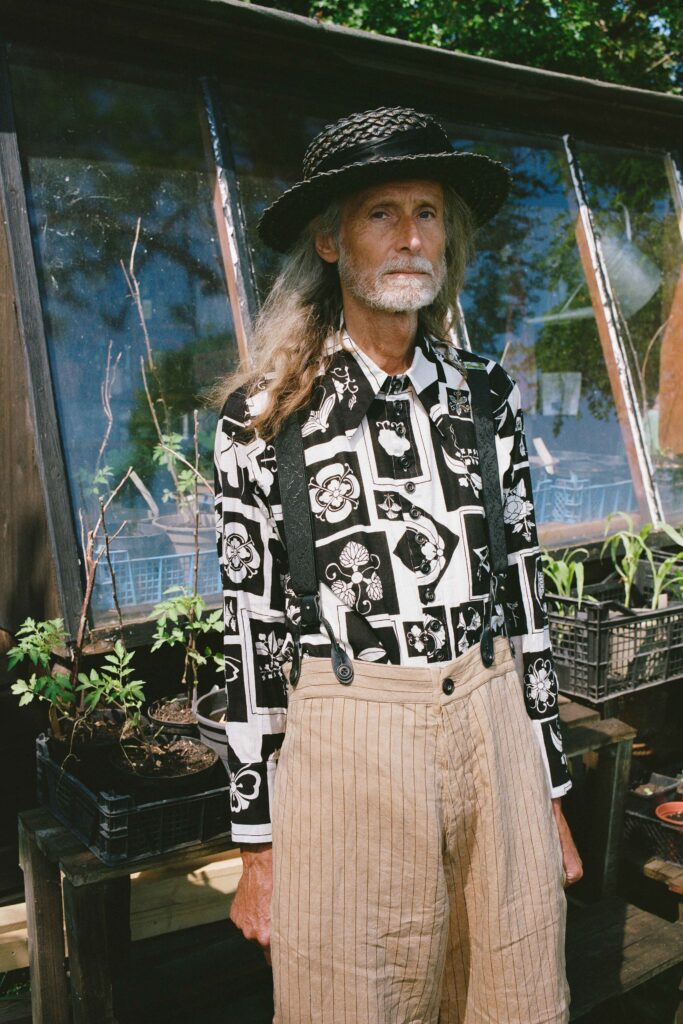 A relaxed black printed long-sleeve shirt paired with beige striped pants.