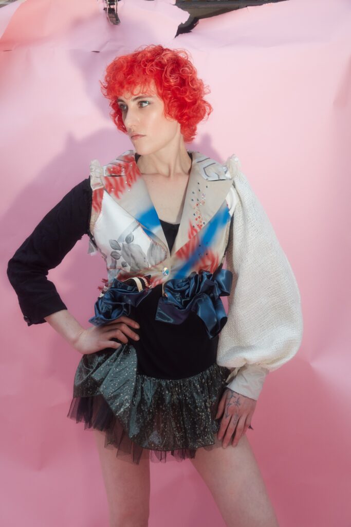 A fitted black multicolor top with long sleeves and a ruffled asymmetric skirt.