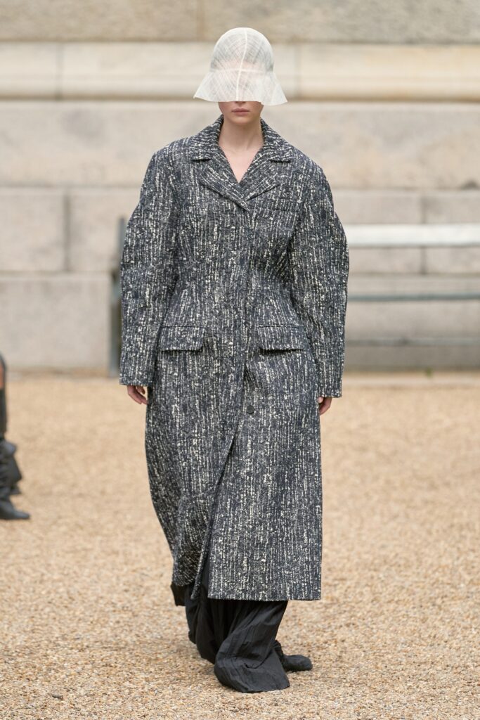An oversized gray cotton coat with a collared neckline and layered design.