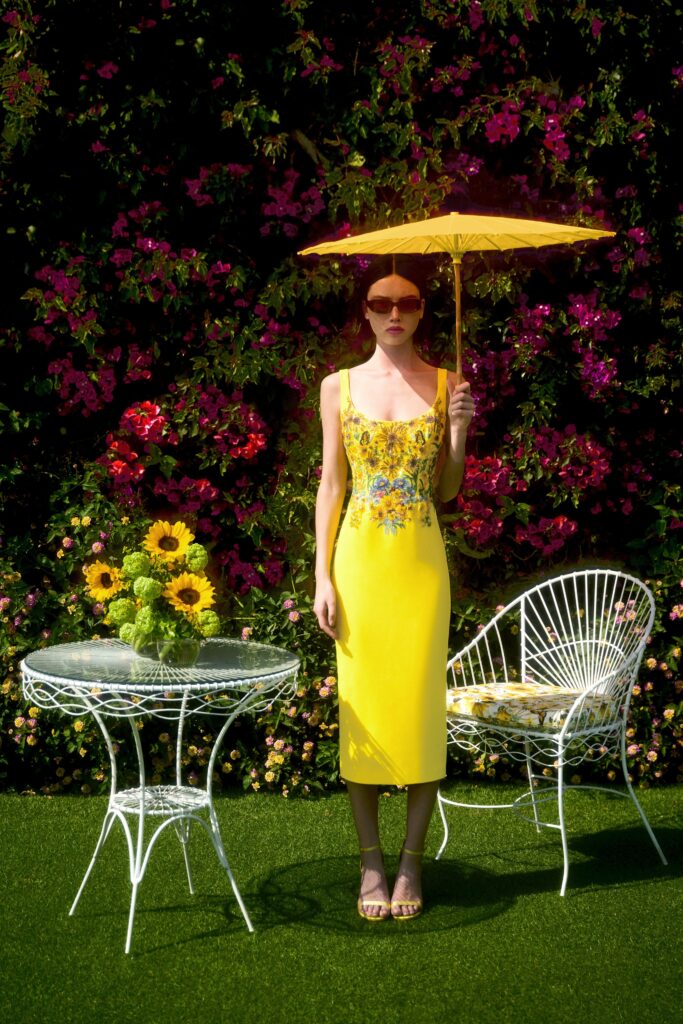 A fitted yellow sleeveless dress with a V-neckline and embroidered details.