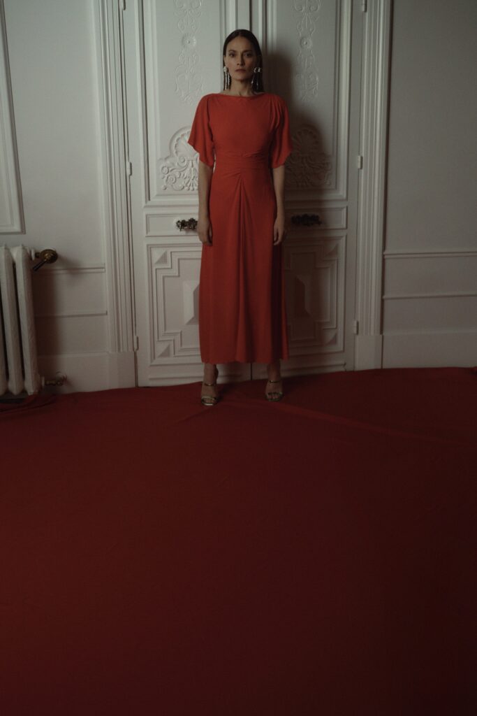 A fitted red silk dress with short sleeves and a V-neckline in a maxi silhouette.
