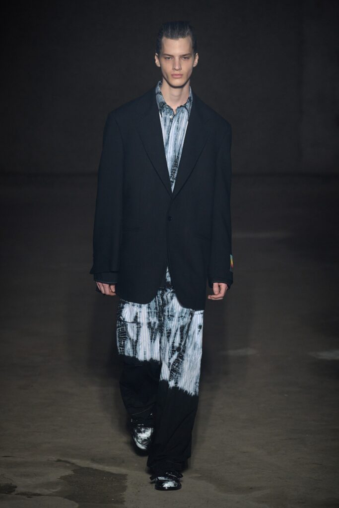 A relaxed black blazer paired with printed pants featuring a long-sleeve collared shirt.