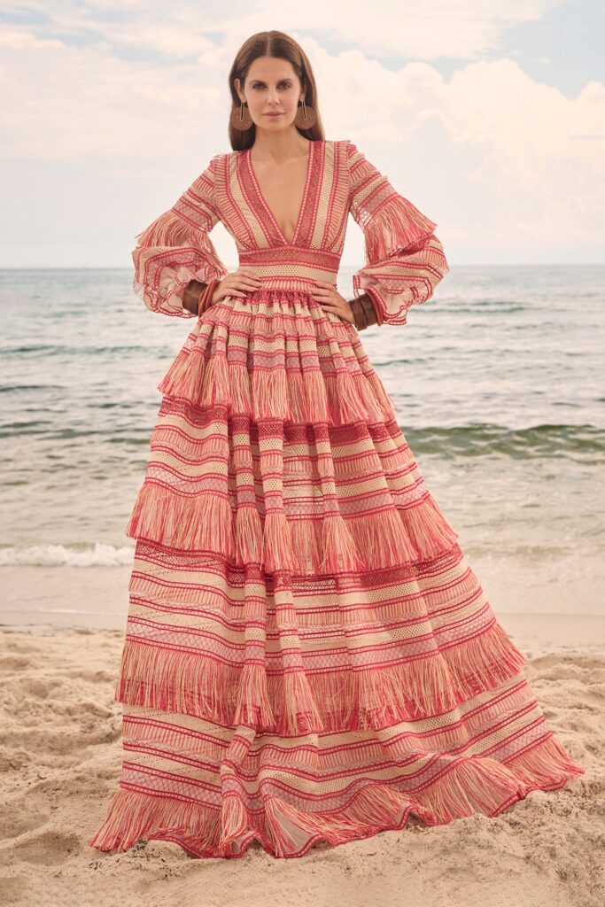 A relaxed red cotton long-sleeve dress with a V-neckline and tiered fringed design.