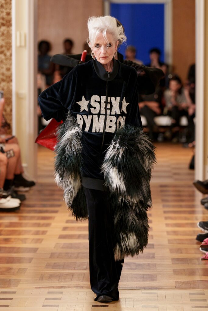 An oversized black velvet coat with fur detailing and long sleeves, paired with matching pants.