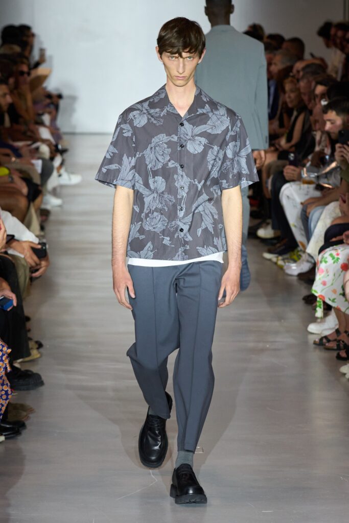 A relaxed gray floral short-sleeve shirt paired with blue pants for a casual look.