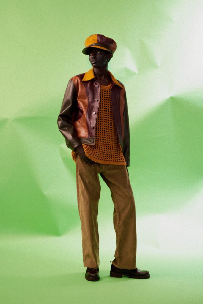 A relaxed brown leather jacket paired with cotton pants in an earthy tone.