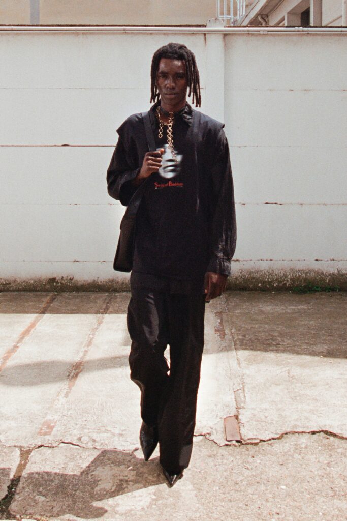 A relaxed black long-sleeve collared shirt paired with straight-leg black pants.