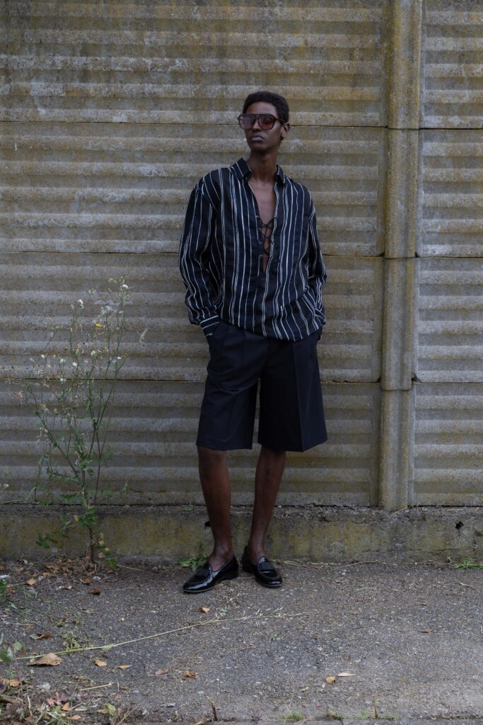 A relaxed black and white striped long-sleeve shirt paired with relaxed black shorts.
