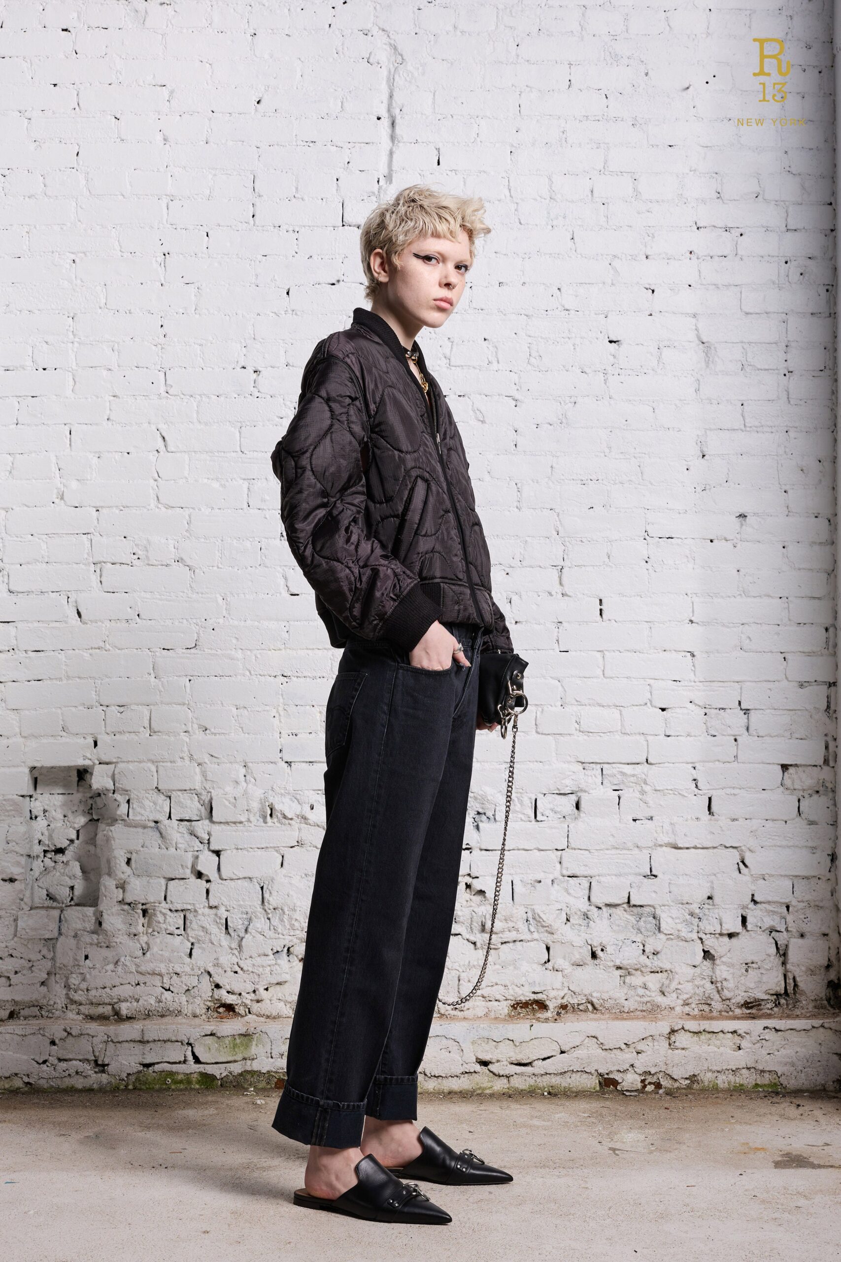 A relaxed black jacket with long sleeves and a collared design paired with black pants.