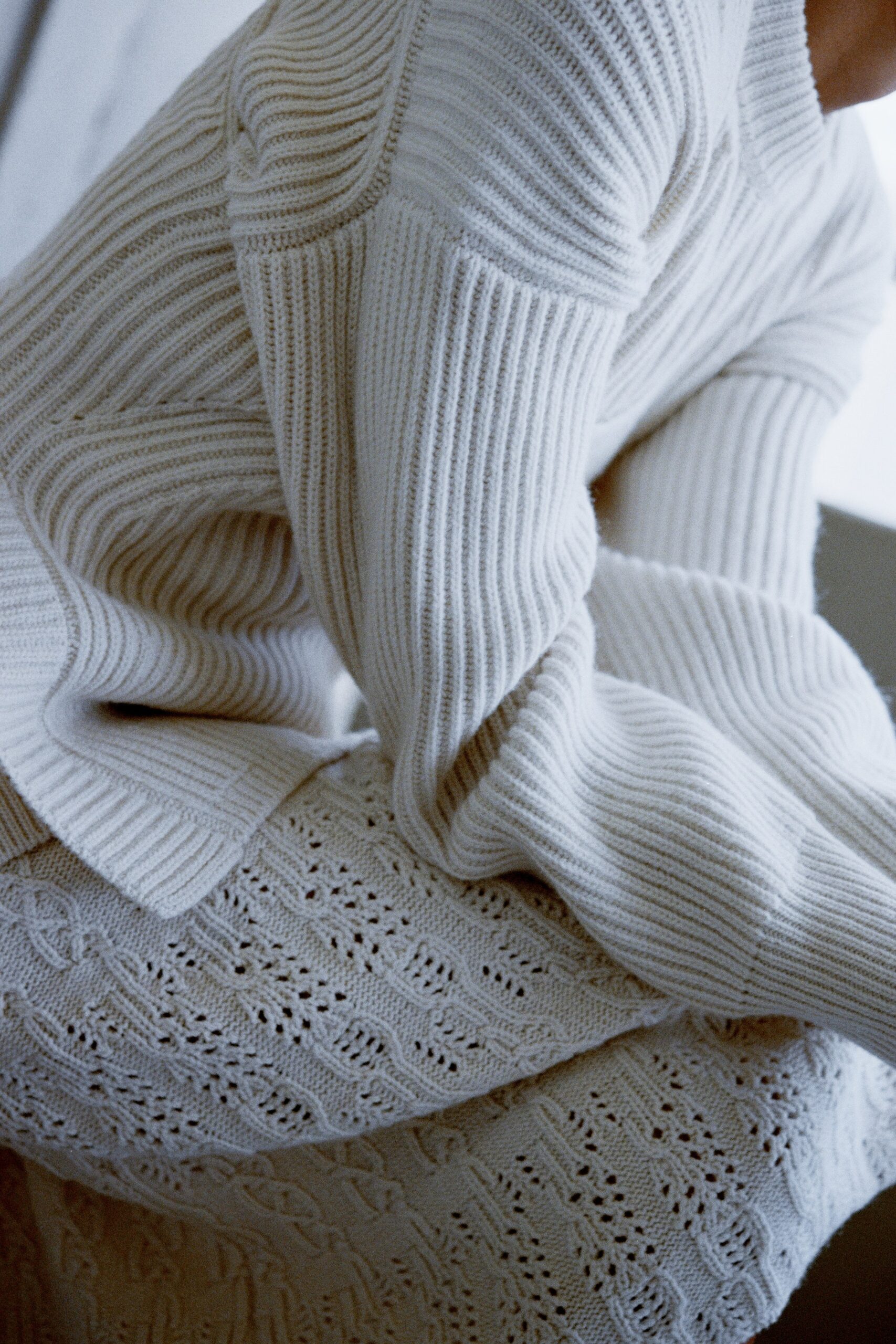 A relaxed white knitted sweater paired with a matching knitted skirt for a cozy look.