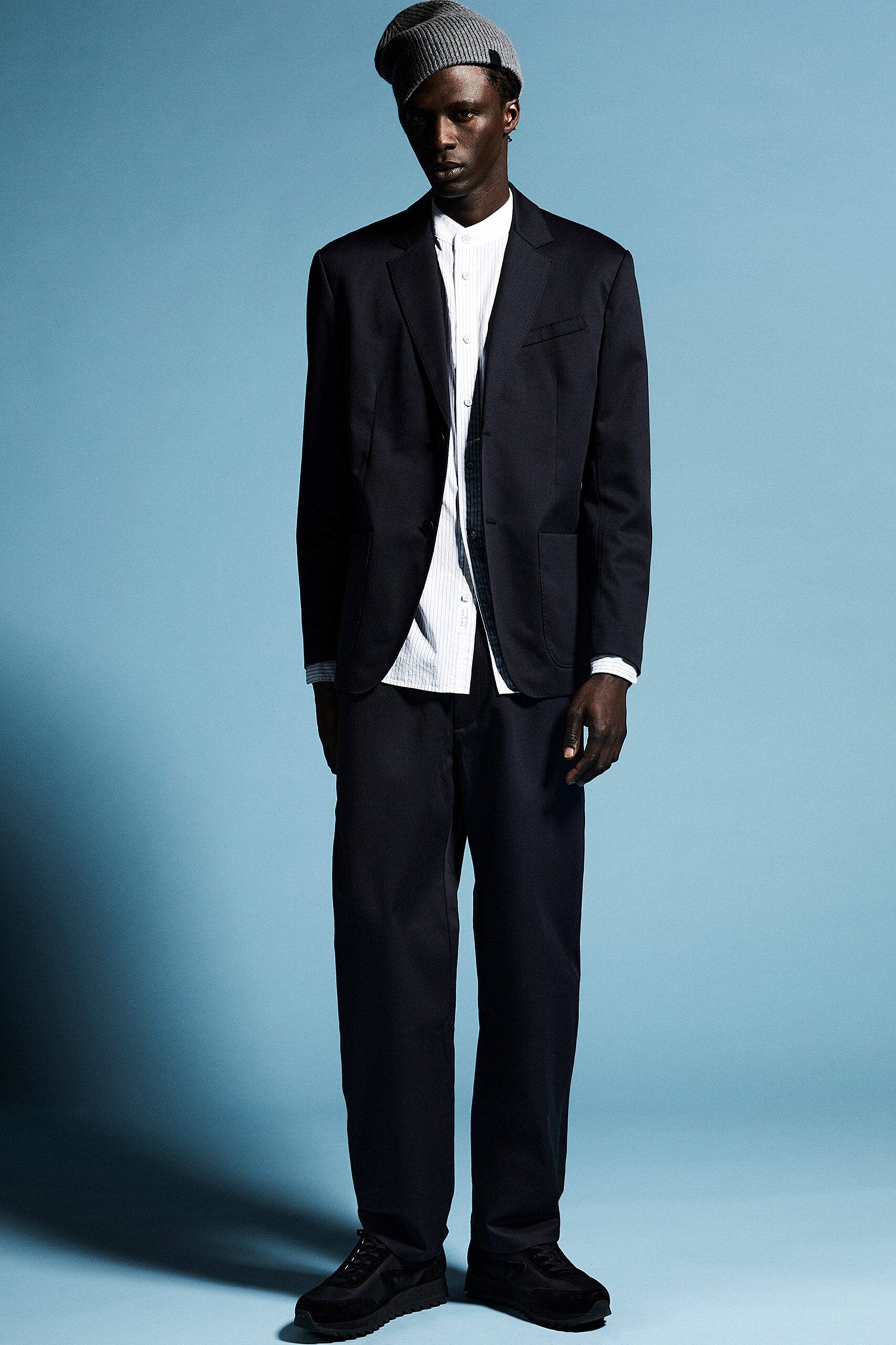 A relaxed black cotton suit featuring a long-sleeve collared shirt and buttoned jacket.