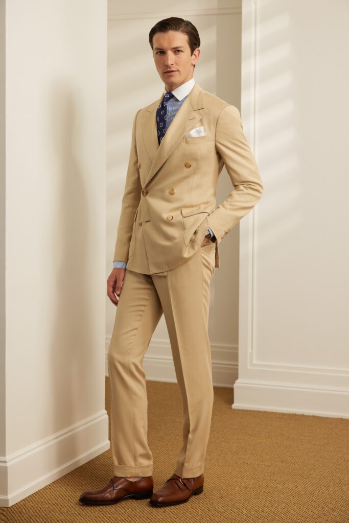 A tailored beige cotton suit with long sleeves and a collared shirt.
