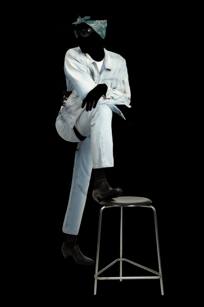 A fitted blue denim jacket with long sleeves and collared neck paired with straight-leg pants.