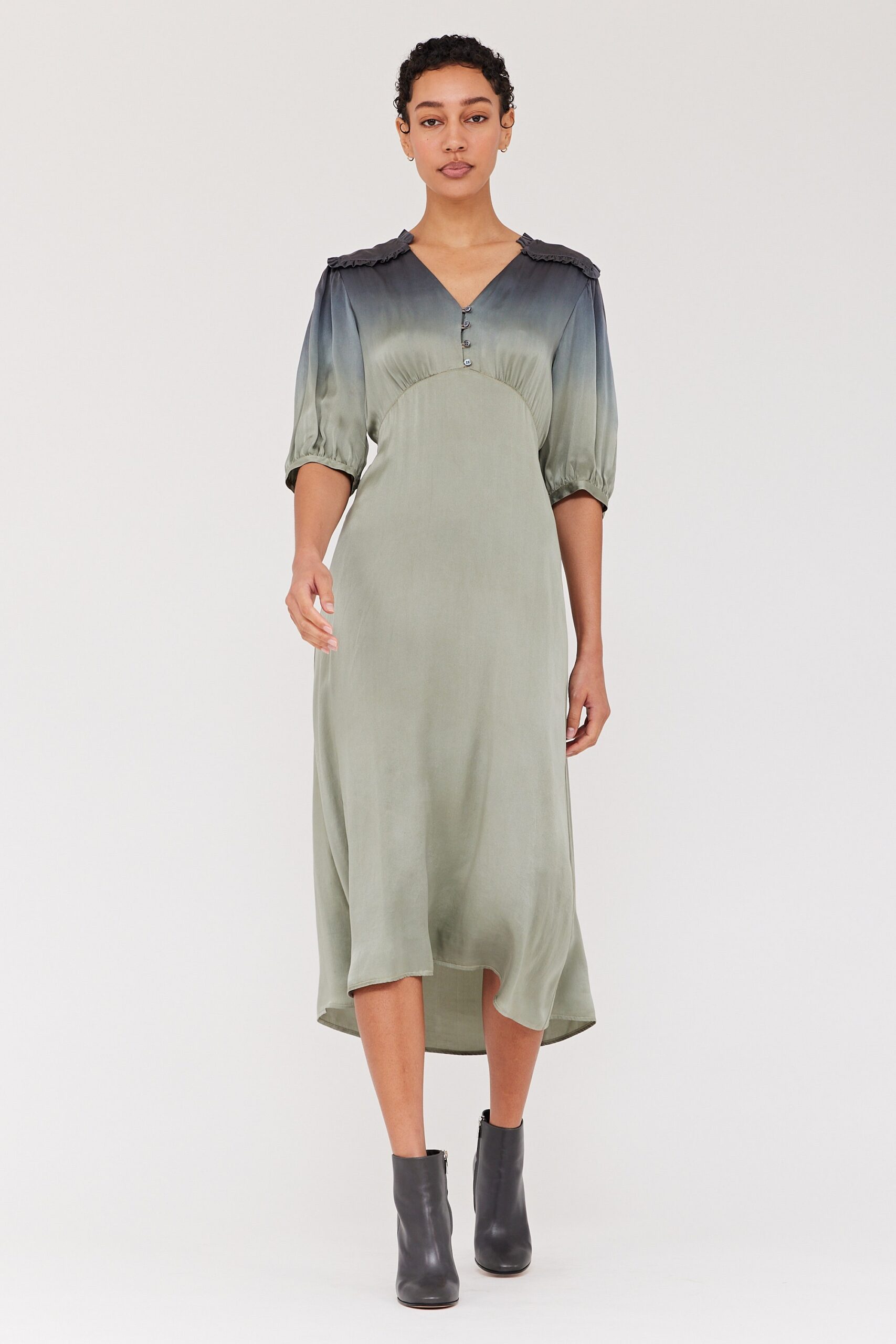 A relaxed green silk dress with a V-neckline and tiered design details.