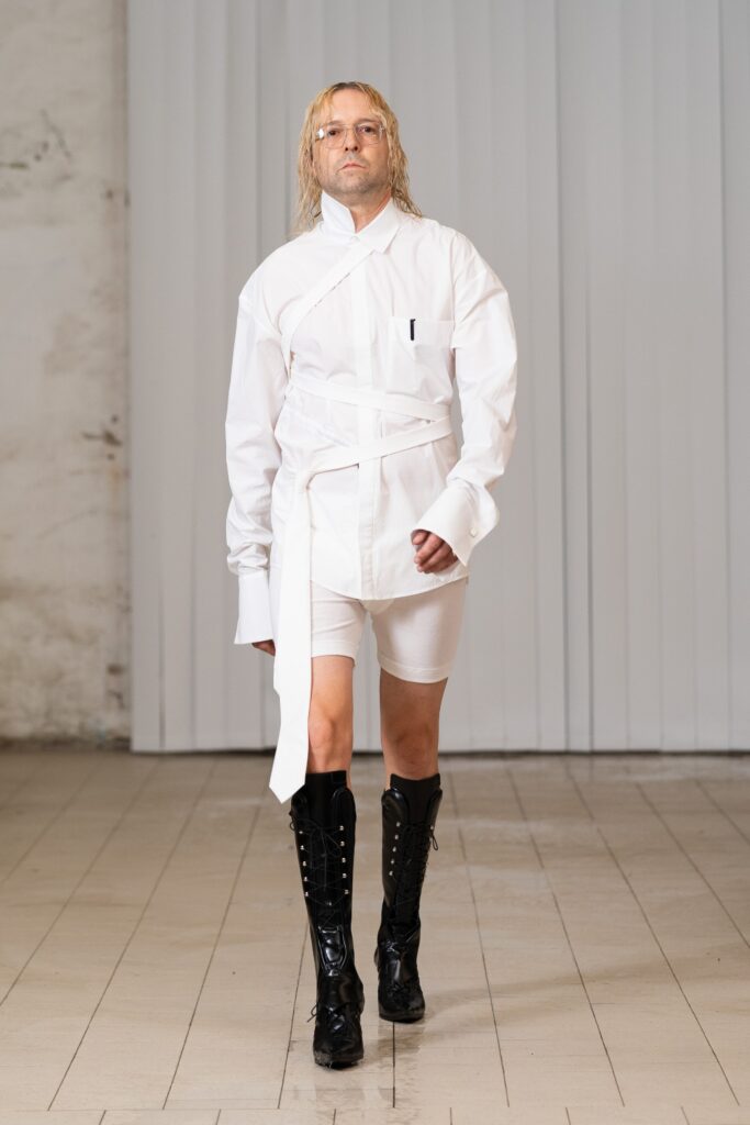 An oversized white shirt paired with fitted white shorts and knee-high boots.