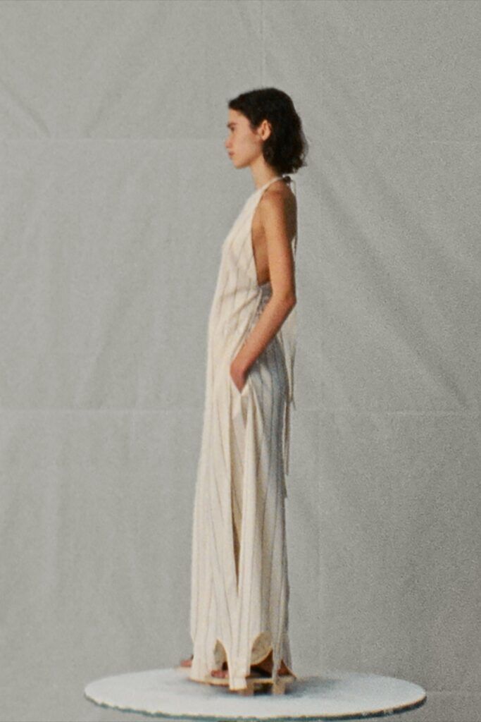 A relaxed beige striped sleeveless dress featuring a V-neckline and maxi length.
