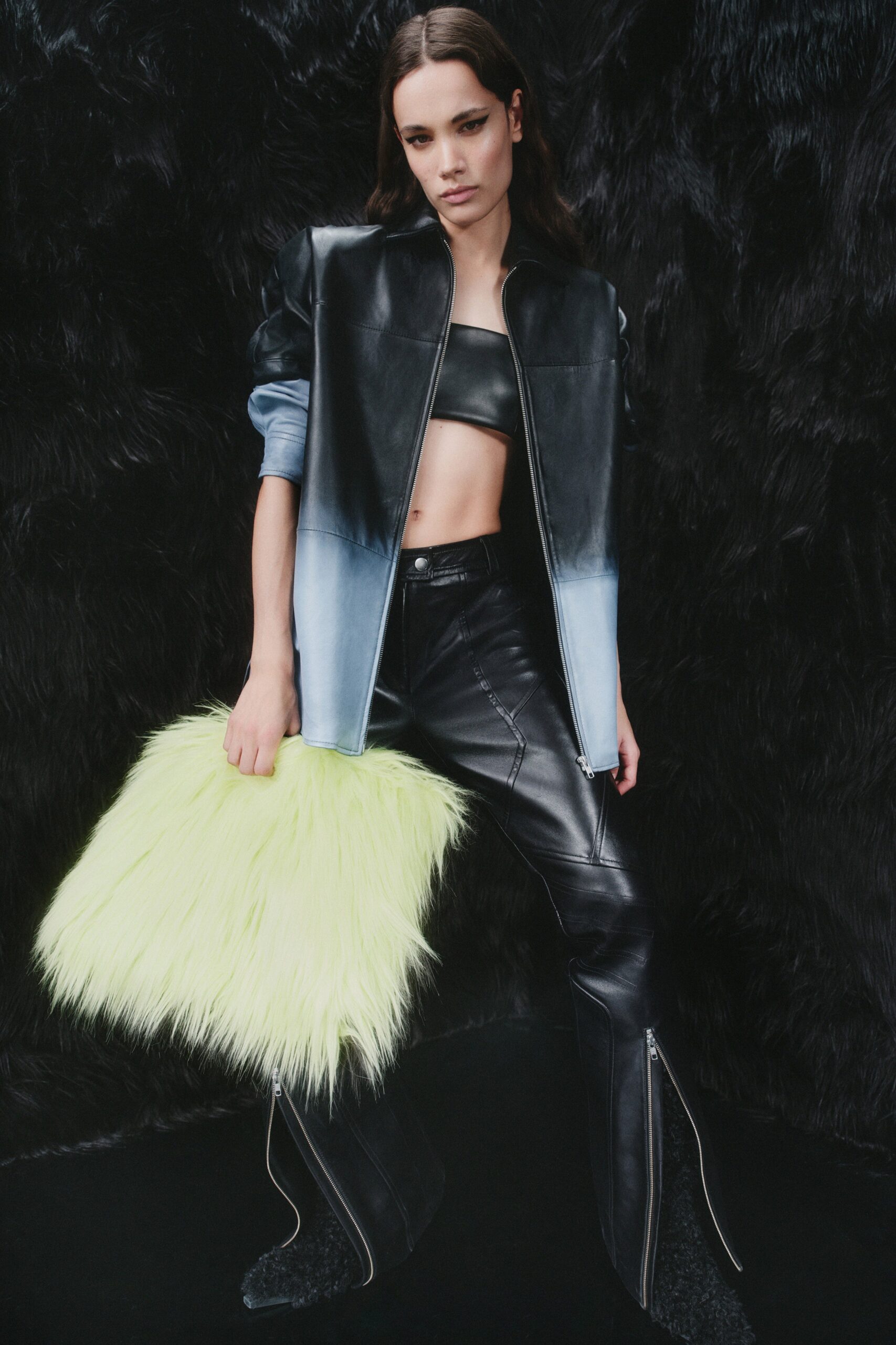 A fitted black leather jacket with a blue gradient and flared pants.